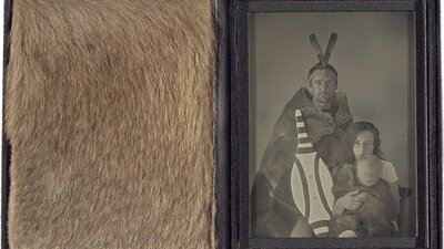 A leather case displaying Grey Kangaroo fur beside a greyscale photograph of a family.