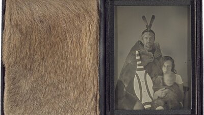A leather case displaying Grey Kangaroo fur beside a greyscale photograph of a family.