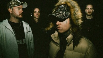 The four band members of thrown in the dark looking various ways.