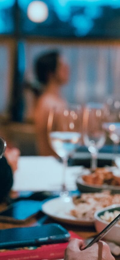 Woman drinking sparkling wine with art model sitting in background