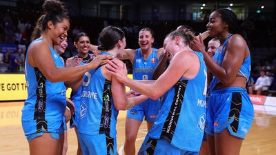 UC Capitals players celebrate in a circle after winning a game.