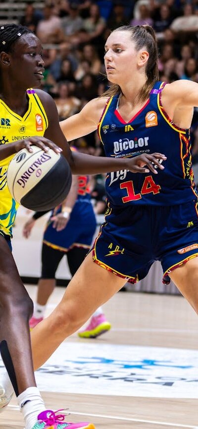 UC Capitals player driving to the basket for a layup during a WNBL game against Adelaide Lightning.