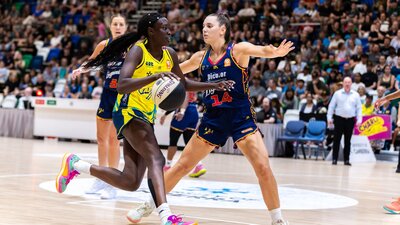UC Capitals player driving to the basket for a layup during a WNBL game against Adelaide Lightning.