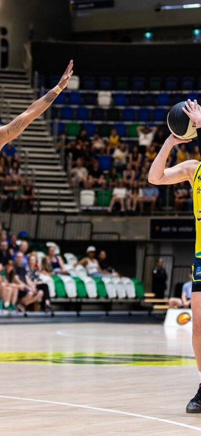 UC Capitals player shooting the basketball while a defender closes in.