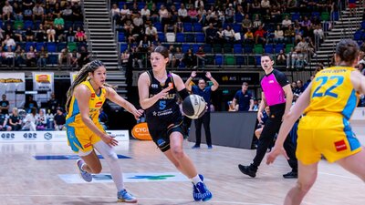 UC Capitals player driving to the basket for a layup during a WNBL game.