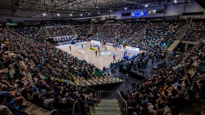A full arena watching a UC Capitals game from the stands.