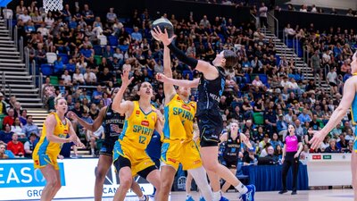 UC Capitals player driving to the basket for a layup during a WNBL game.