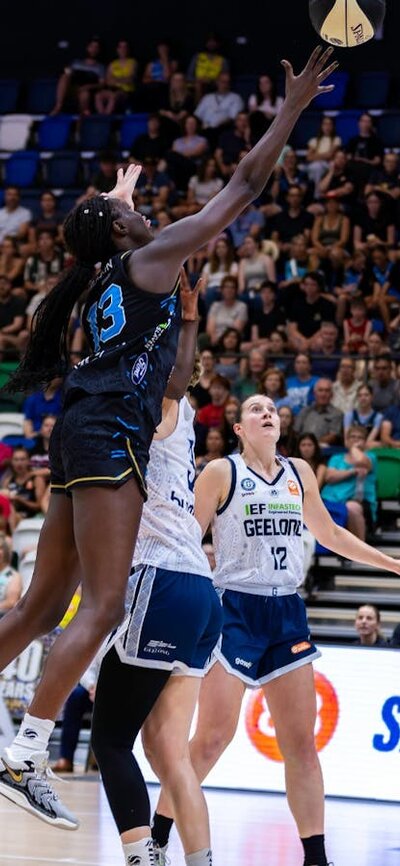 UC Capitals player driving to the basket for a layup during a WNBL game.