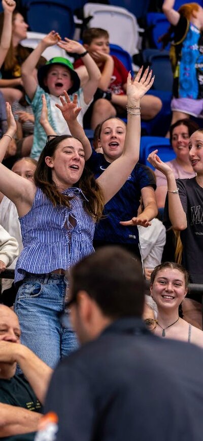 Crowd cheering and jumping at a UC Capitals game.