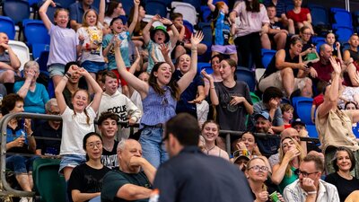 Crowd cheering and jumping at a UC Capitals game.