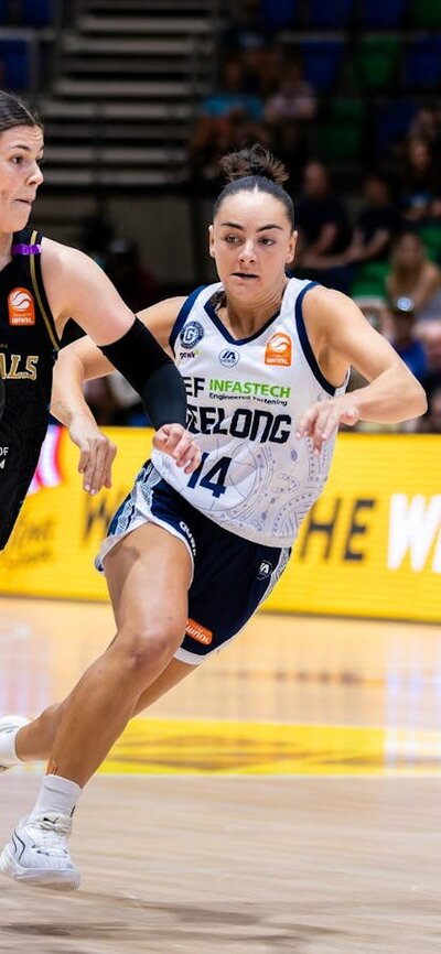 UC Capitals player driving to the basket for a layup during a WNBL game.