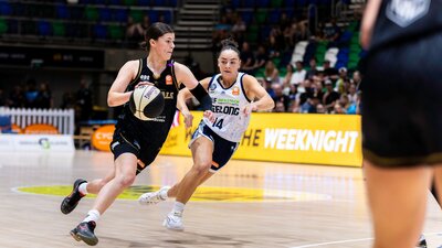 UC Capitals player driving to the basket for a layup during a WNBL game.