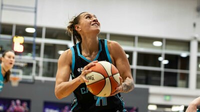 Basketball player goes up for a shot attempt.