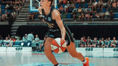 Basketball player dribbles the ball while running.