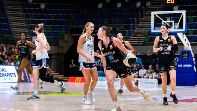 UC Capitals player driving to the basket for a layup during a WNBL game.