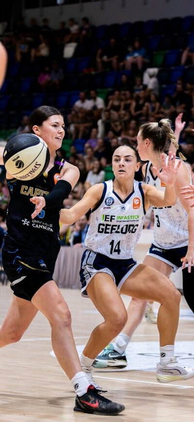 UC Capitals player passing the basketball during a game.