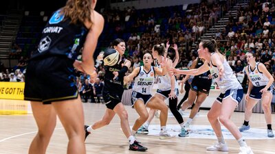 UC Capitals player passing the basketball during a game.