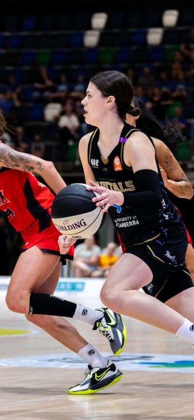 UC Capitals player driving to the basket for a layup during a WNBL game.