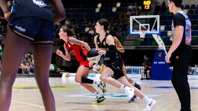 UC Capitals player driving to the basket for a layup during a WNBL game.