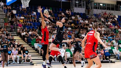 UC Capitals player driving to the basket for a layup during a WNBL game.