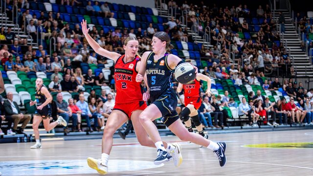 UC Capitals player driving to the basket for a layup during a WNBL game against Perth Lynx.