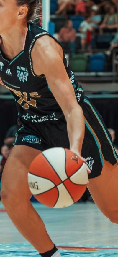 Basketball player dribbles the ball while running.