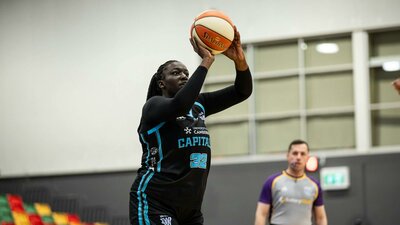 Basketball player goes up for a shot attempt.