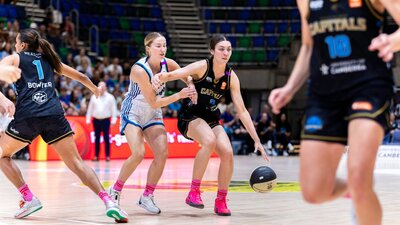 UC Capitals player driving to the basket for a layup during a WNBL game.