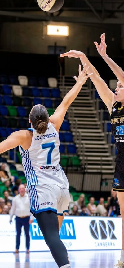 UC Capitals player shooting the basketball while a defender closes in.