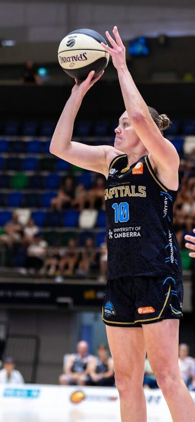 UC Capitals player about to shoot a basketball while a defender has their hand out.