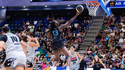 UC Capitals player driving to the basket for a layup during a WNBL game.