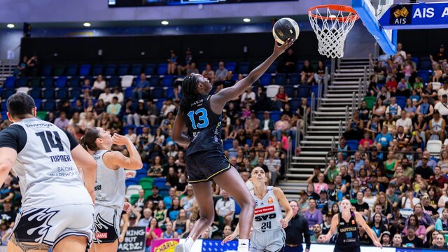 UC Capitals player driving to the basket for a layup during a WNBL game.