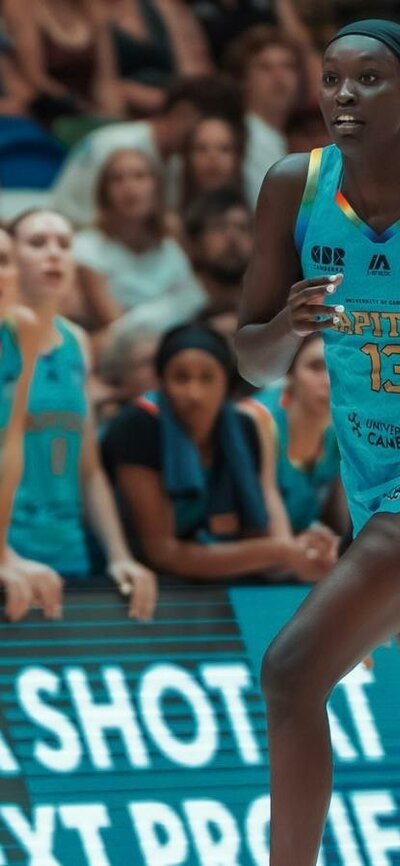 Basketball player drives down the court with the basketball.