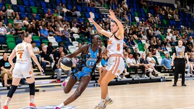 UC Capitals player driving to the basket for a layup during a WNBL game against Townsville Fire.