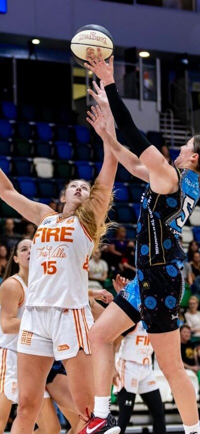 UC Capitals player driving to the basket for a layup during a WNBL game against Townsville Fire.