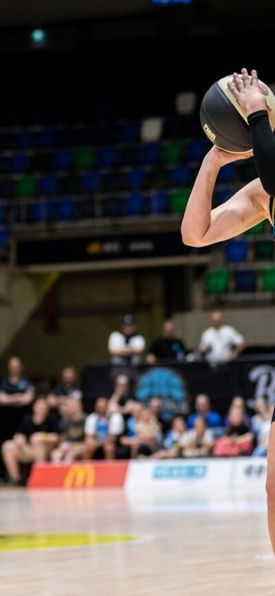 UC Capitals player preparing to shoot a basketball during a WNBL game against Townsville Fire.
