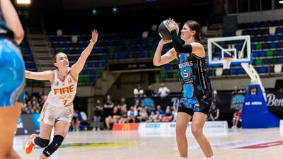 UC Capitals player preparing to shoot a basketball during a WNBL game against Townsville Fire.
