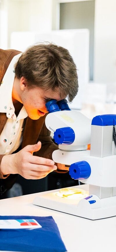 A prospective student looking through a microscope in one of the many scientific laboratories