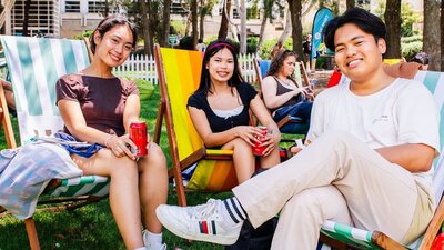 Students relaxing in garden lounge chairs at Open Day Fest