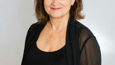 Smiling woman with shoulder-length brown hair wearing concert blacks