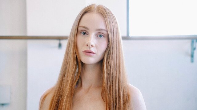 Vera Blue looking directly at the camera in a bright room