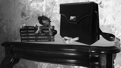 Untitled 1 (Still Life of a Ramindjeri Elder) by Hayley Millar-Baker black and white image, satchel, books and flower sitting on table