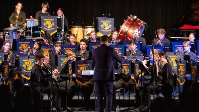 Children's band performance with a conductor.