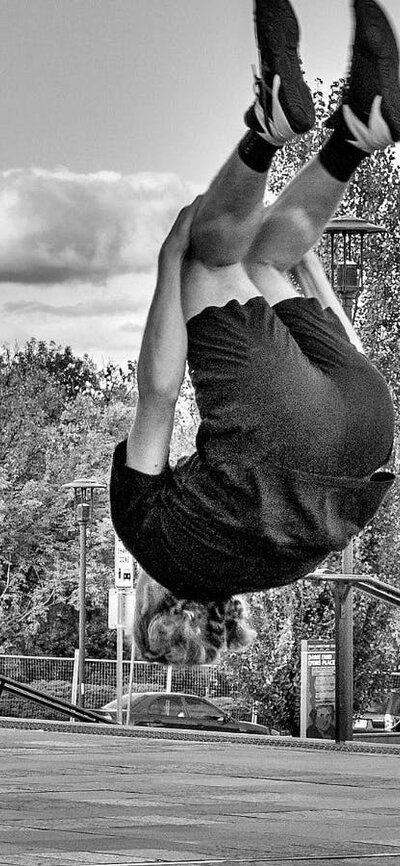 Learn Acrobatics at Warehouse Circus these ACT school holidays 3 young men perform a backsault.