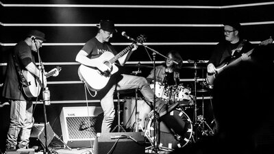 Black and white image of a band on stage