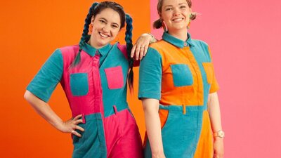 Two woman stadning together wearing colourful jumpsuits