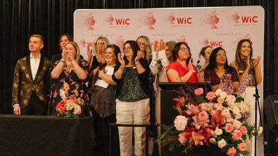 Members of WIC's board standing on stage and applauding