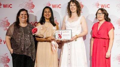 Sampurna Sen on stage receiving her award from Alicia Payne MP, joined by WIC board members