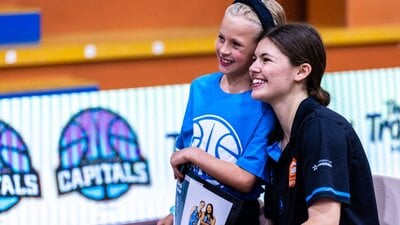 Basketball player posing for photo with young fan.