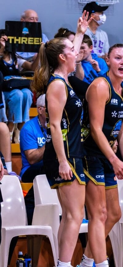 The bench players of a basketball team cheering.